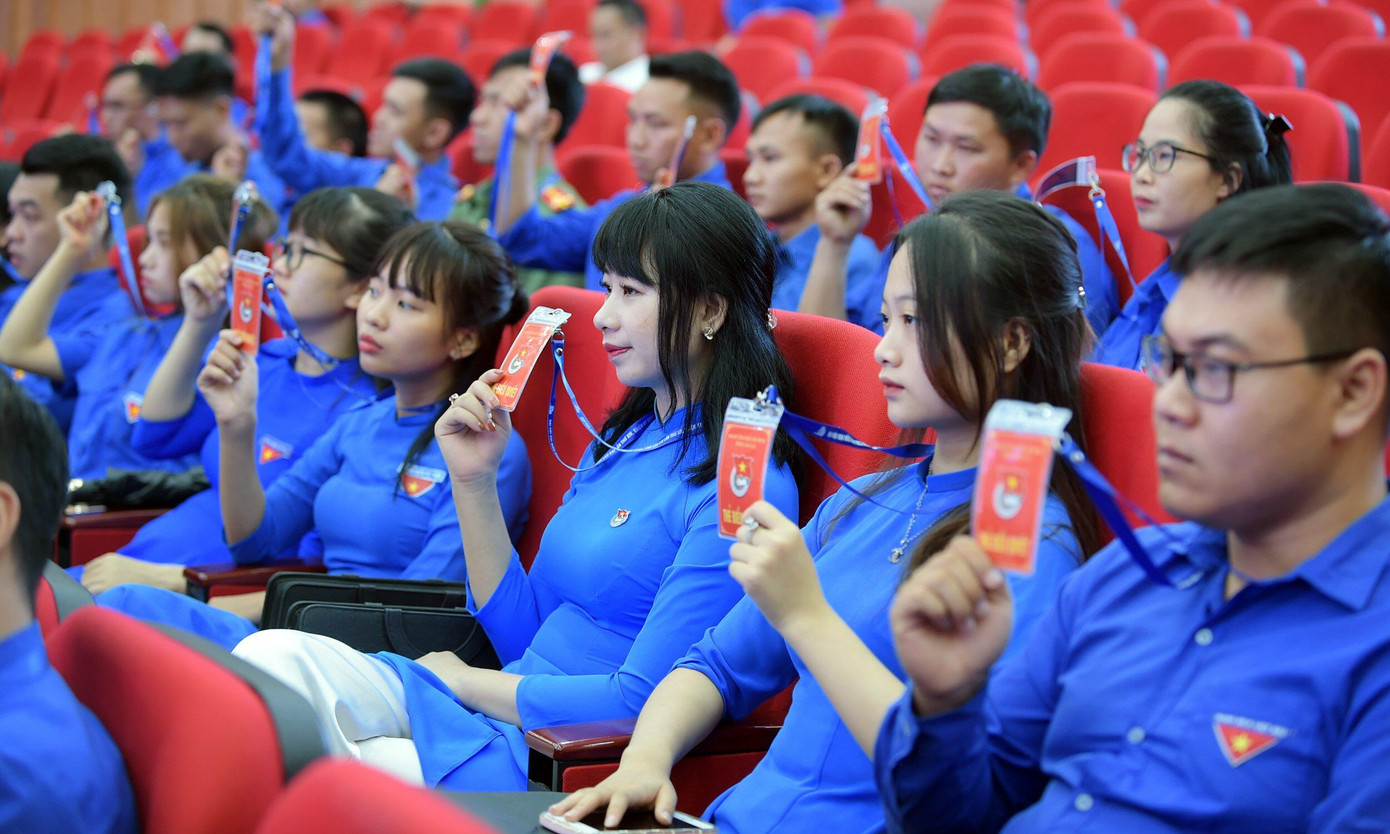 Các đại biểu đồng loạt giơ thẻ biểu quyết. Các đại biểu đồng loạt giơ thẻ biểu quyết.