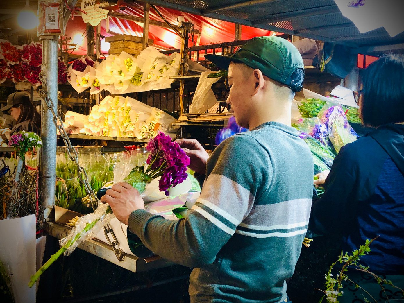 Nhiều bạn trẻ cũng lặn lội đến chợ hoa từ nửa đêm để chọn mua hoa làm quà. Anh Nguyễn Quang Thái (áo trắng, 22 tuổi) cho biết: "8/3 năm nào mình cũng đến đây mua hoa về cắm để tặng bà và mẹ của mình vì ở đây có nhiều mẫu mã và giá cả bao giờ cũng rẻ hơn những chỗ khác". Ảnh: Ngọc Hân
