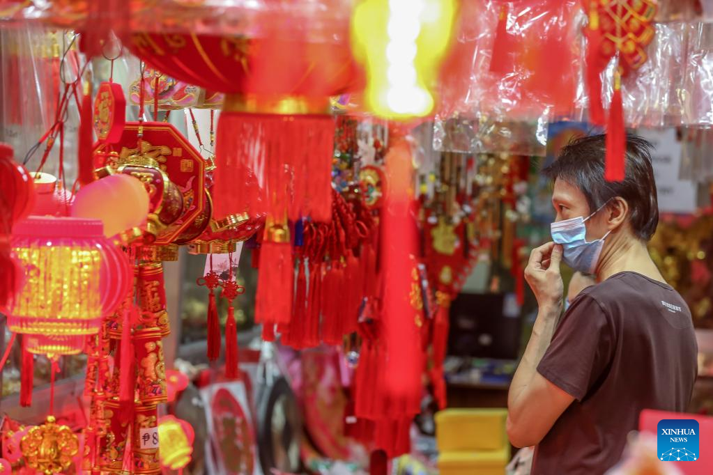 Một cư dân Manila (Philippines) chăm chú chọn mua đồ trang trí năm mới. Ảnh: Tân Hoa Xã