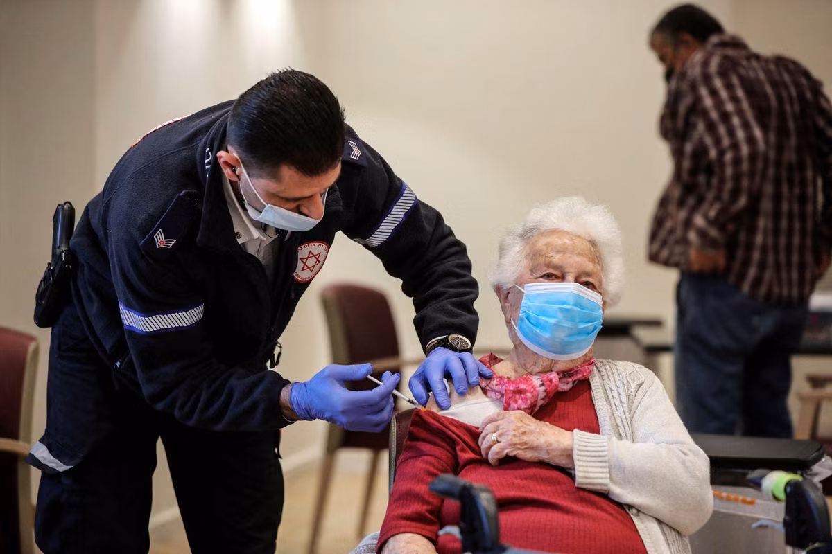 Cụ bà Shari Marco (93 tuổi) được tiêm liều vắc xin thứ tư ở Netanya (Israel). Ảnh: Reuters
