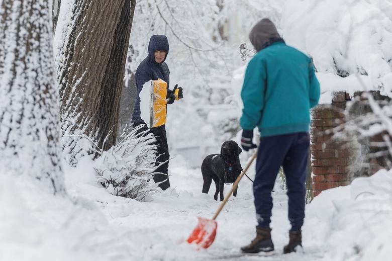 Một cư dân Washington dọn tuyết trước cửa nhà. Ảnh: Reuters