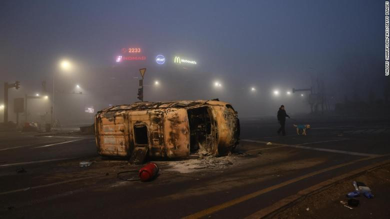 Một chiếc xe hơi bị thiêu rụi nằm chỏng chơ trên đường phố Almaty. Ảnh: Tass Một chiếc xe hơi bị thiêu rụi nằm chỏng chơ trên đường phố Almaty. Ảnh: Tass