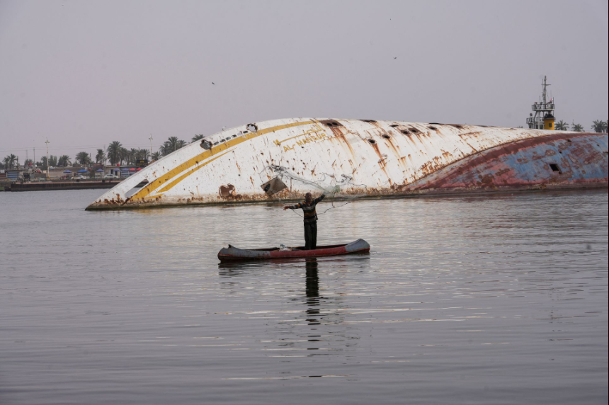 Một ngư dân Iraq quăng lưới gần chiếc du thuyền lật nghiêng. (Ảnh: Reuters) Một ngư dân Iraq quăng lưới gần chiếc du thuyền lật nghiêng. (Ảnh: Reuters)