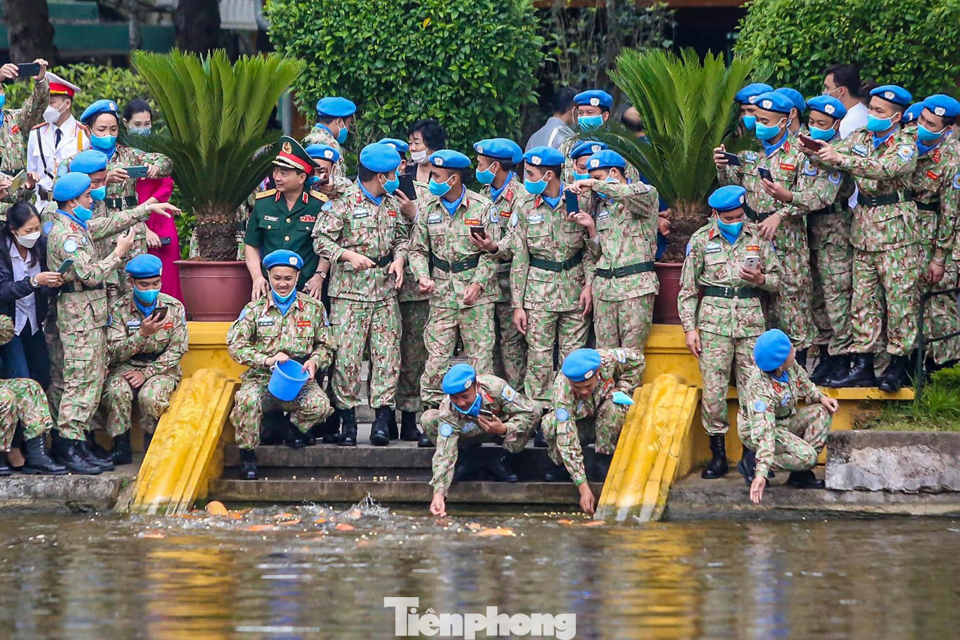 Các chiến sĩ mũ nồi xanh thích thú cho cá ăn tại ao cá Bác Hồ.