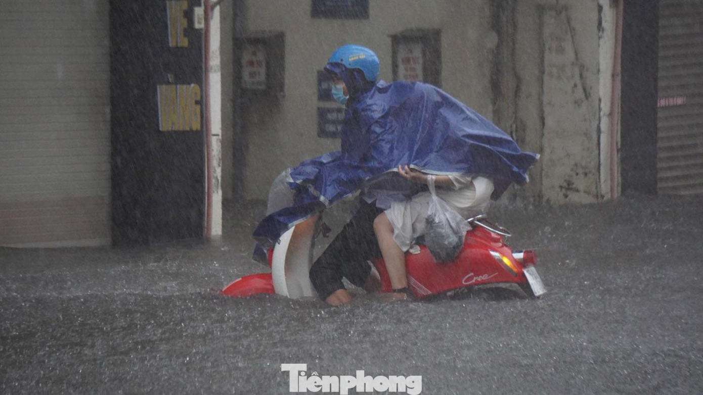 Trong khi đó, nhiều học sinh khác di chuyển qua điểm nước ngập sâu, không kịp lên hè phố trú mưa, bị ướt.