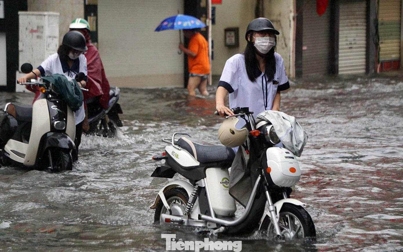 Hàng loạt học sinh dắt xe qua điểm ngập sâu trên phố Tô Hiệu sáng 5/9.