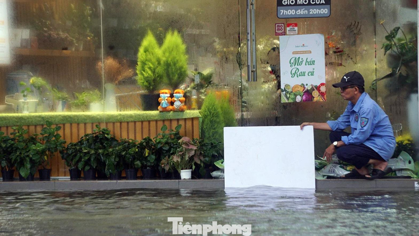 Bảo vệ một cửa hàng trên phố Lê Lợi (TP Hải Phòng) ngăn sóng đánh vào cửa kính.