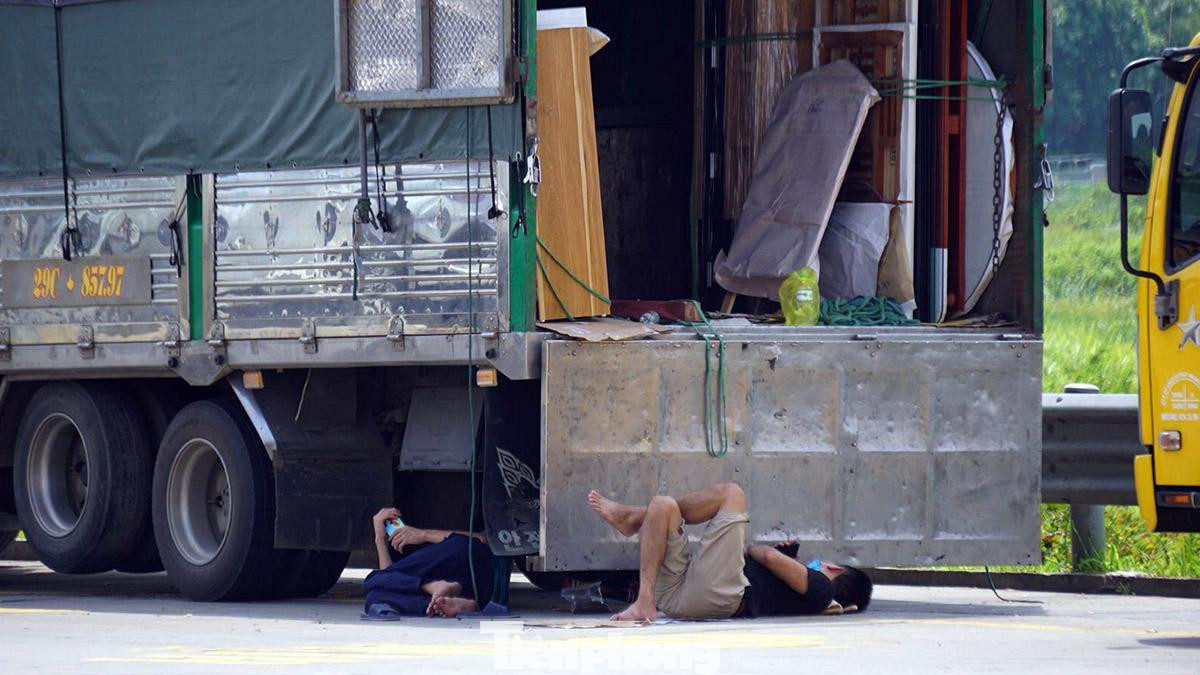 Một số tài xế, phụ lái nằm ngủ dưới gầm xe tải chờ hàng giữa trưa. Một số tài xế, phụ lái nằm ngủ dưới gầm xe tải chờ hàng giữa trưa.