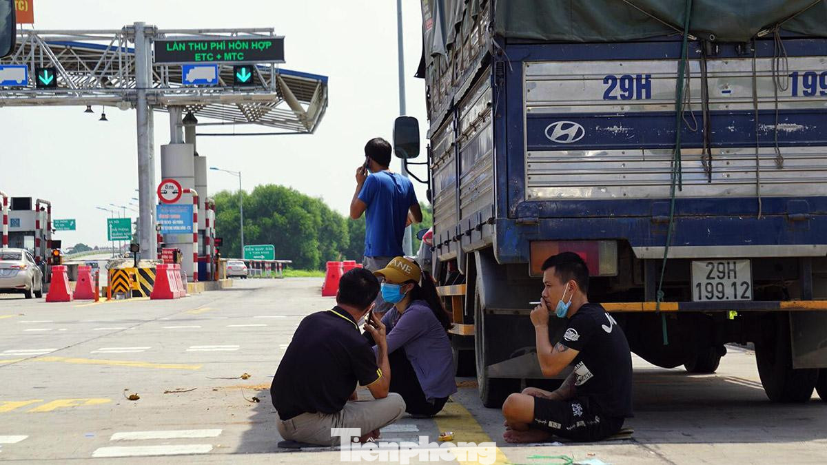 Trong khi chờ đợi, nhiều người ngồi dưới bóng xe tải tránh nắng. Trong khi chờ đợi, nhiều người ngồi dưới bóng xe tải tránh nắng.