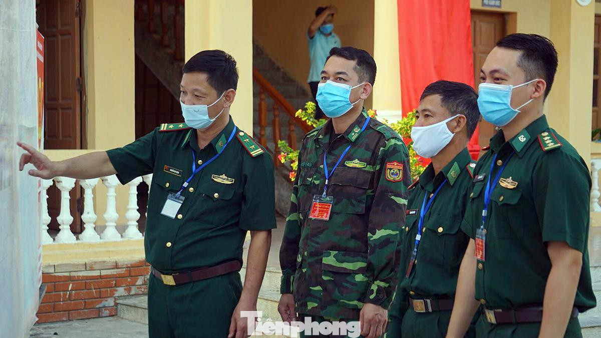 Trung tá Nguyễn Duy Bách - Đồn trưởng Biên phòng Bạch Long Vỹ cùng đồng đội trao đổi về thông tin các ứng cử viên ĐBQH khóa XV, HĐND các cấp nhiệm kỳ 2021-2026.