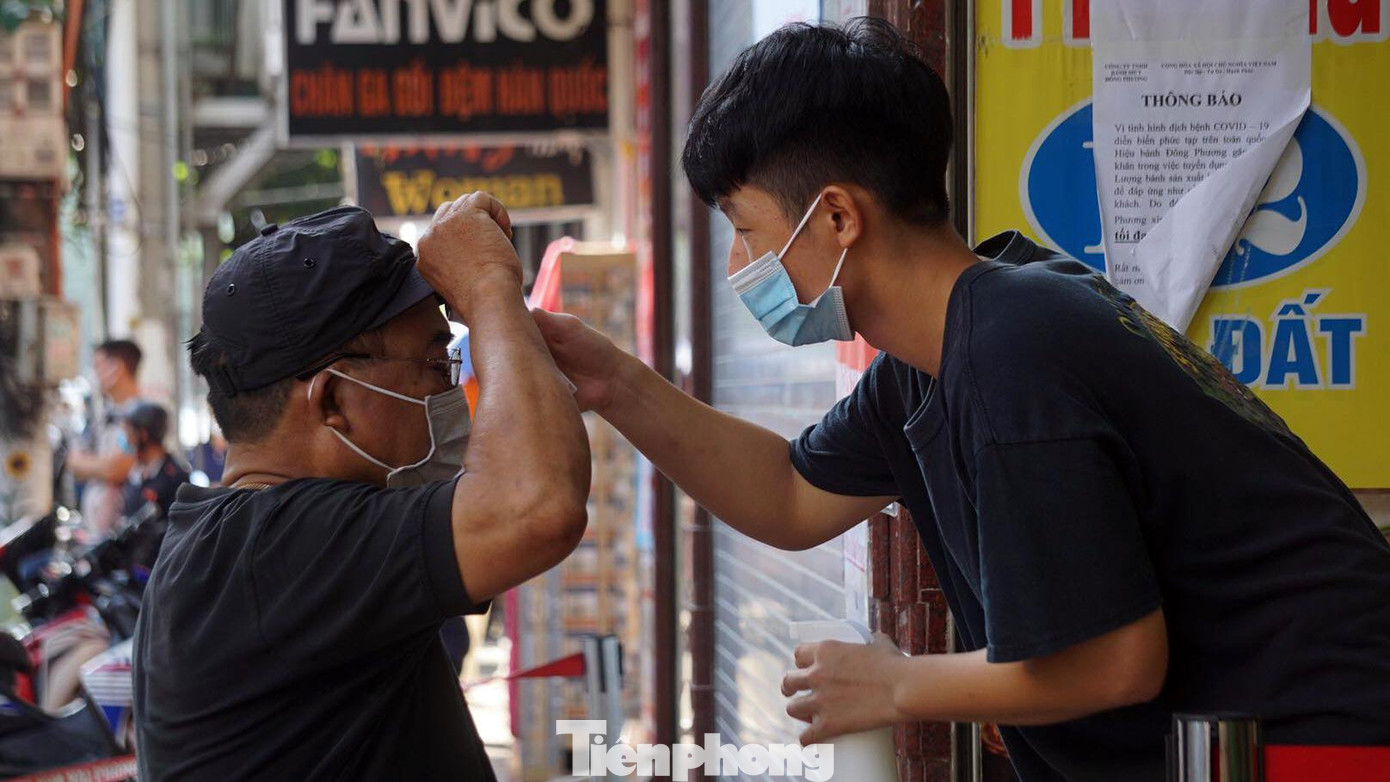 Các cửa hàng bán bánh truyền thống trên phố Cầu Đất yêu cầu khách đo thân nhiệt, rửa tay sát khuẩn và tuân thủ giãn cách khi vào mua bánh.