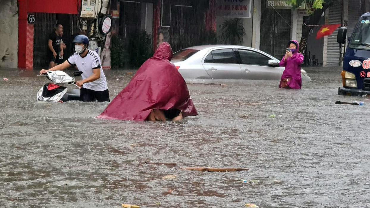 Cảnh người dân dầm mưa dắt xe qua phố Cầu Đất.