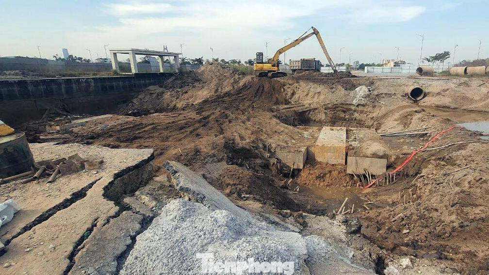 Nhiều mảng đường đã thảm nhựa bị rạn nứt sau sự cố. Một số công nhân điều khiển máy xúc múc bùn đất lên để khắc phục sự cố tại công trường.