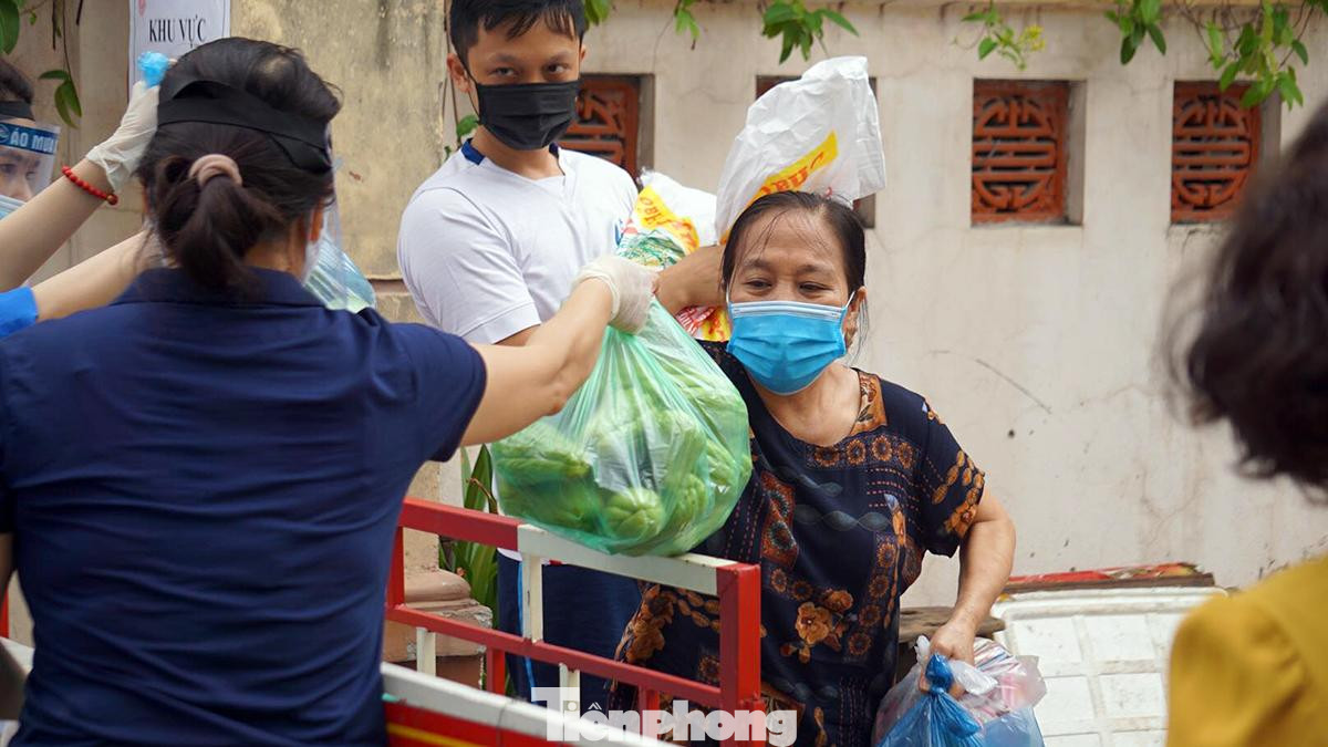 Sau khi hoàn tất các thủ tục, biện pháp phòng chống dịch, lần lượt đại diện các hộ dân tới nhận thực phẩm.