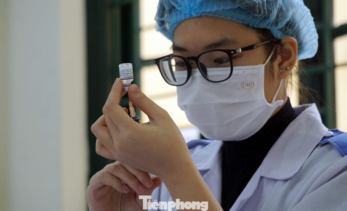 Nhân viên y tế pha dung môi với vắc xin chuẩn bị tiêm cho học sinh Trường THPT Ngô Quyền.