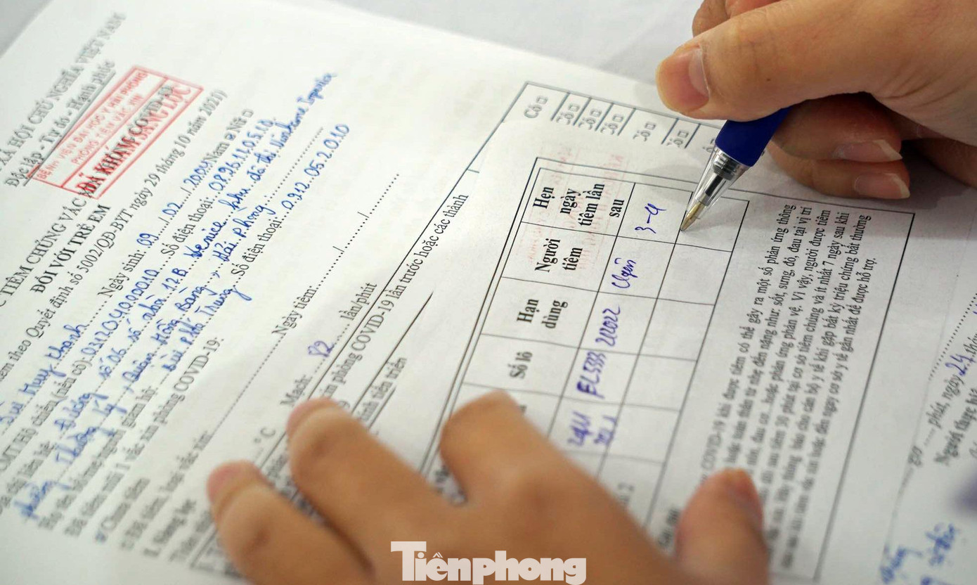 Nhân viên y tế kiểm tra lại thông tin học sinh đăng ký để nhập lên hệ thống tiêm chủng quốc gia và điền thông tin lộ trình tiêm vắc xin cho học sinh theo dõi, thực hiện.