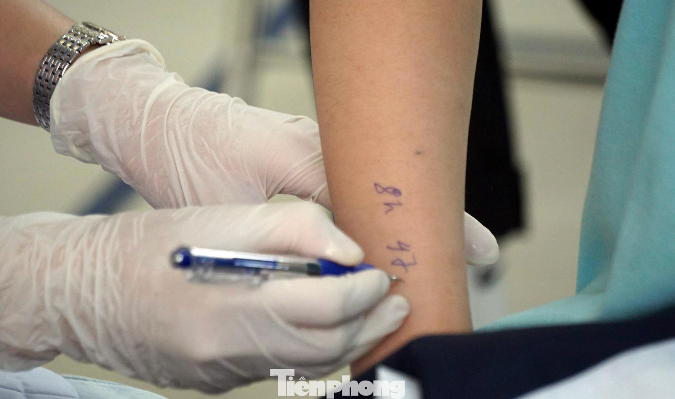 Lực lượng y tế ghi thời điểm tiêm vắc xin để học sinh tiện theo dõi sức khỏe sau tiêm.