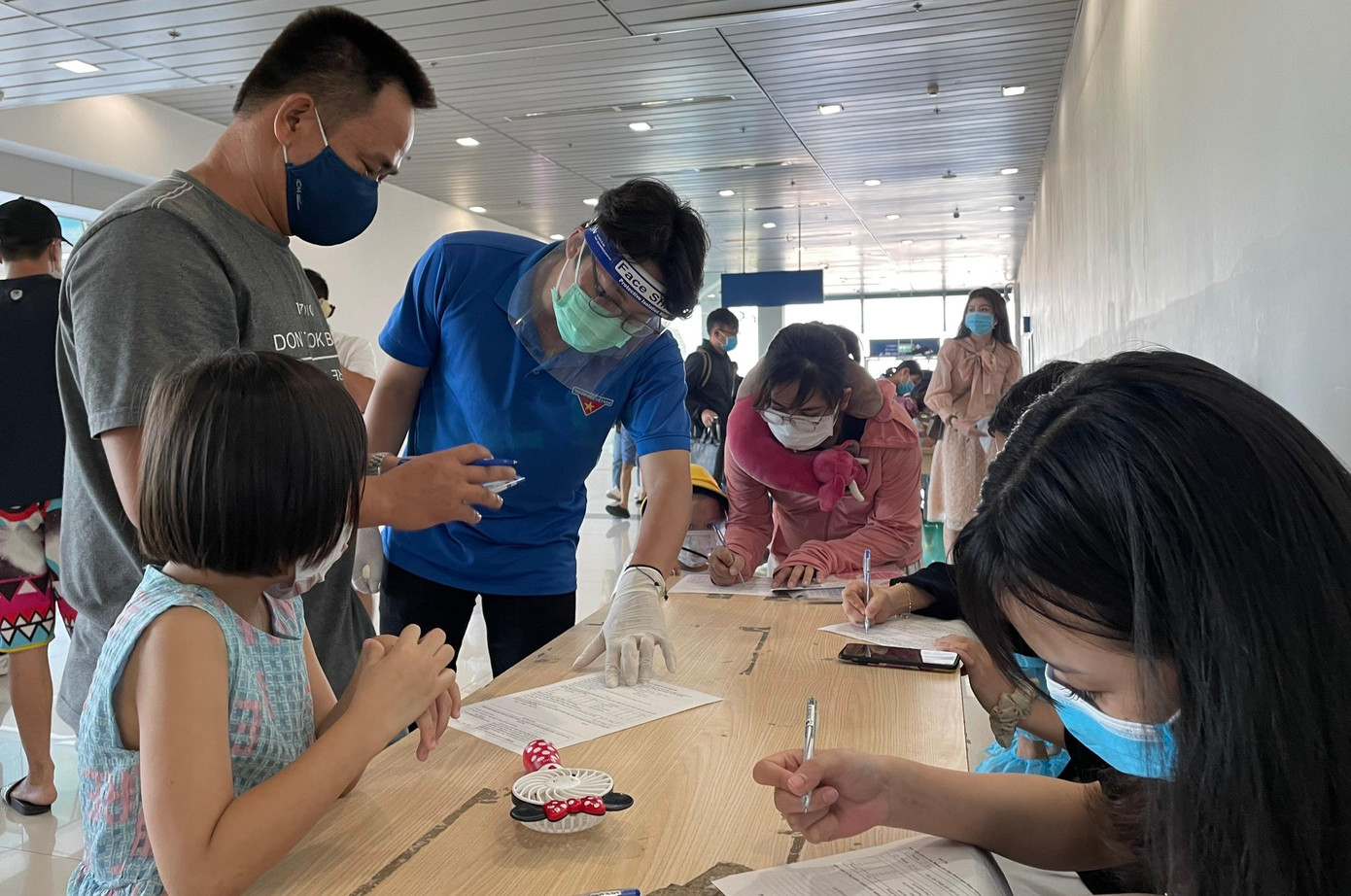 Thanh niên tình nguyện ở Hải Phòng hướng dẫn người trở về từ TP Hồ Chí Minh khai báo y tế tại Sân bay quốc tế Cát Bi.