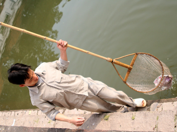 Dùng vợt để dọn tiền dưới lòng hồ