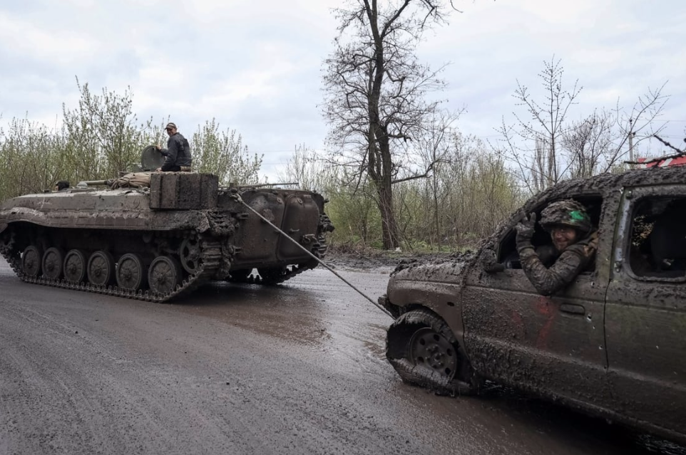 Lính Ukraine dùng xe chiến đấu bộ binh BMP-1 kéo một chiếc ô tô bị hỏng ở khu vực gần tiền tuyến vùng Donetsk ngày 22/4. (Ảnh: Reuters)