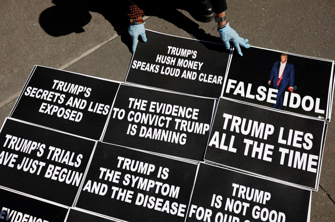 Một người đặt các tấm in khẩu hiệu phản đối ông Trump trước toà án ở Manhattan ngày 27/3. (Ảnh: CNN) Một người đặt các tấm in khẩu hiệu phản đối ông Trump trước toà án ở Manhattan ngày 27/3. (Ảnh: CNN)