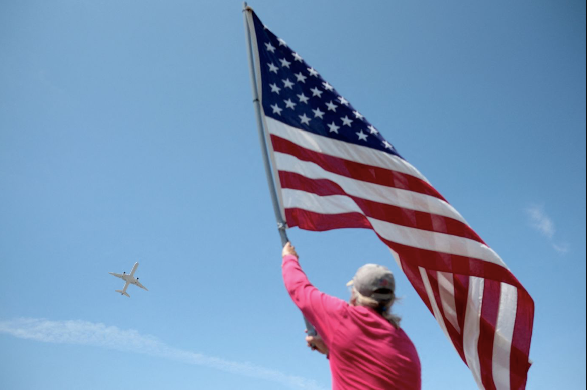 Một người vẫy quốc kỳ khi máy bay riêng chở ông Trump cất cánh từ sân bay quốc tế Palm Beach. (Ảnh: CNN) Một người vẫy quốc kỳ khi máy bay riêng chở ông Trump cất cánh từ sân bay quốc tế Palm Beach. (Ảnh: CNN)