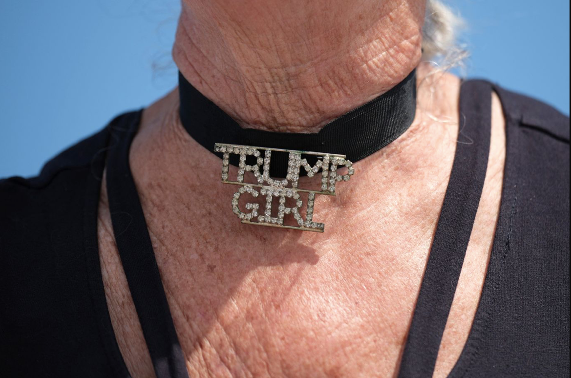 Một cụ bà đeo choker có chữ "Trump Girl" bên ngoài khu biệt thự Mar-a-Lago ngày 2/4. (Ảnh: CNN) Một cụ bà đeo choker có chữ "Trump Girl" bên ngoài khu biệt thự Mar-a-Lago ngày 2/4. (Ảnh: CNN)