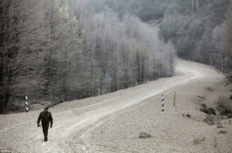 Một cảnh sát đi giữa đá sạn và tro bụi núi lửa ở miền nam Chile . Một cảnh sát đi giữa đá sạn và tro bụi núi lửa ở miền nam Chile