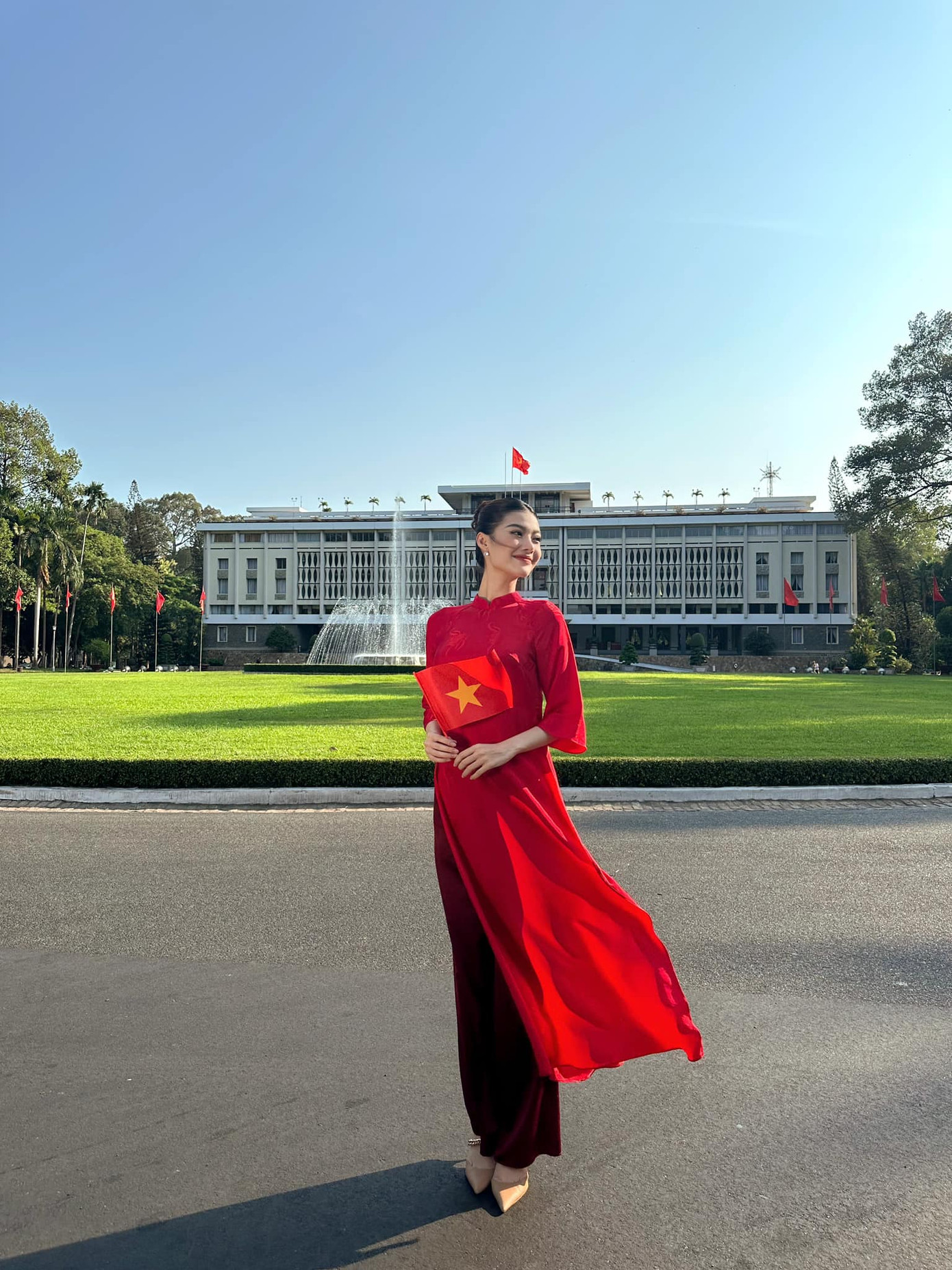 Á hậu Kiều Loan chọn áo dài đỏ khi chụp ảnh trước Dinh Độc Lập trong ngày lễ 30/4. "Tự hào là người con của Việt Nam", người đẹp chia sẻ.