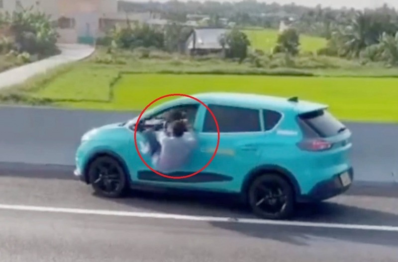 Hình ảnh ông Long chui ra từ vị trí cửa kính của xe taxi trên cao tốc.