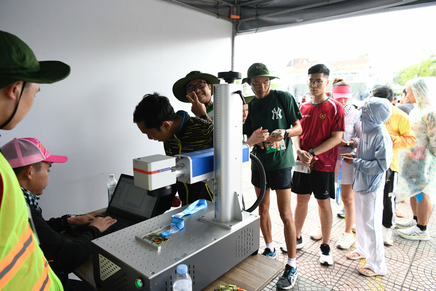 Năm nay, Ban tổ chức tiếp tục chương trình khắc tên trên huy chương. Dù trời mưa, các vận động viên vẫn kiên nhẫn chờ đợi. Năm nay, Ban tổ chức tiếp tục chương trình khắc tên trên huy chương. Dù trời mưa, các vận động viên vẫn kiên nhẫn chờ đợi.