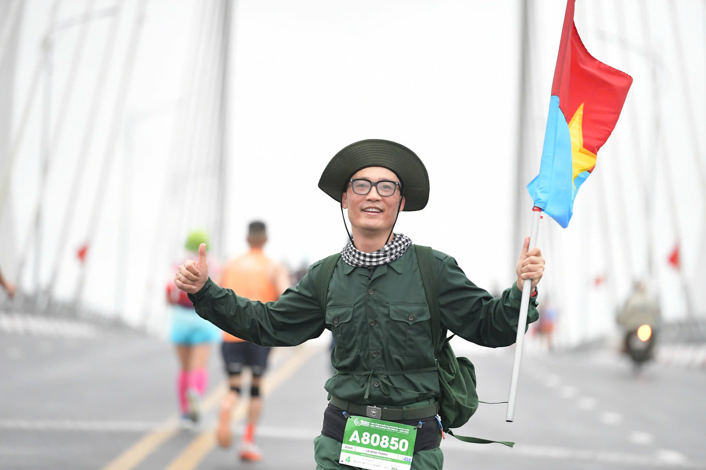 Một runner với trang phục chiến sỹ giải phóng cùng lá cờ Mặt trận Giải phóng miền Nam trên cầu An Lạc.