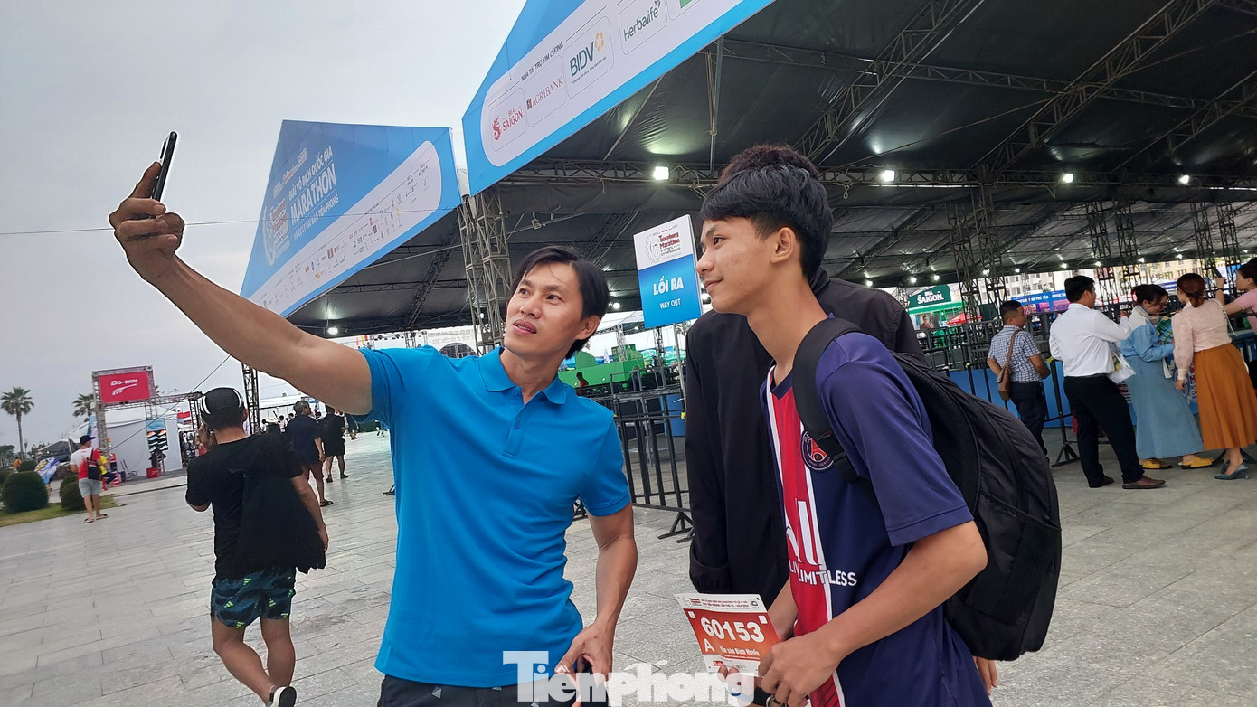 Anh Bình (áo xanh) cùng nhóm bạn check-in cùng bib chạy của Tiền Phong Marathon 2024. Nhóm bạn trẻ này cũng là người Phú Yên và đang tìm mua thêm bib chạy 10km do có người không đăng ký kịp.
