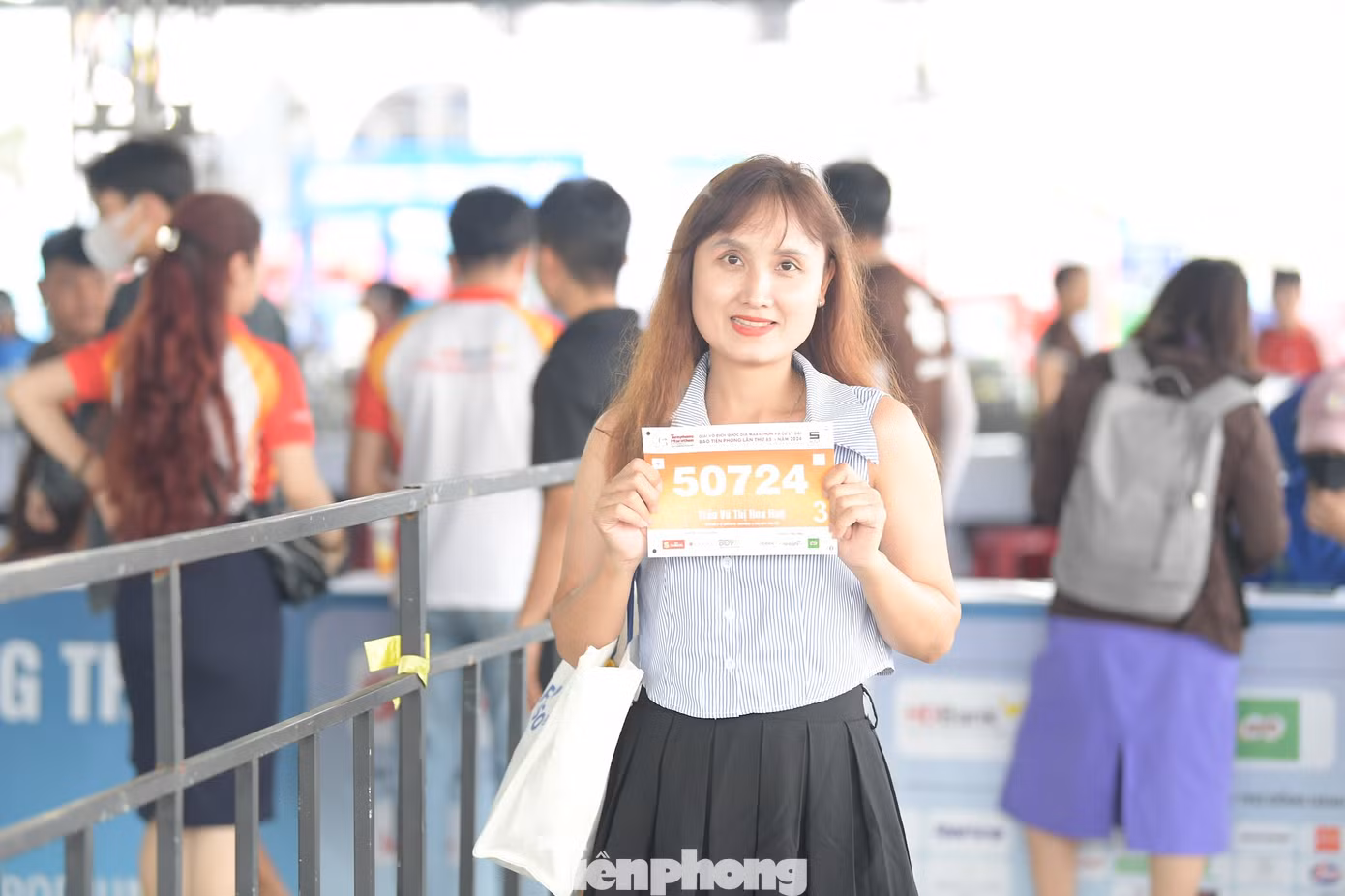 Một nữ VĐV khoe bib trước khi nhận race kit.