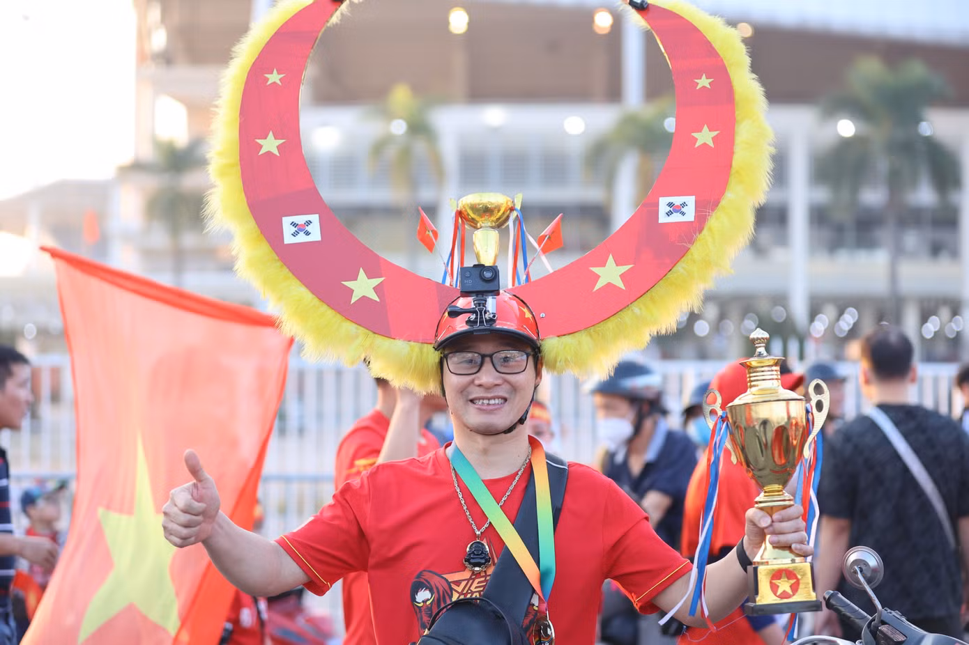 Một CĐV với phiên bản mini của chiếc Cúp AFF Cup.