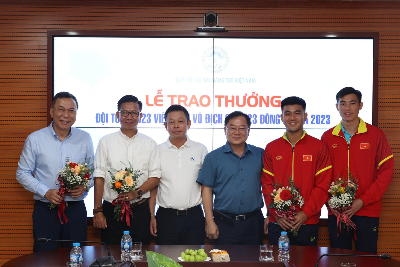 Chủ tịch Liên đoàn Bóng đá Việt Nam (VFF) Trần Quốc Tuấn, nhà báo Lê Xuân Sơn - Tổng biên tập báo Tiền Phong, Giám đốc Quỹ hỗ trợ tài năng trẻ Việt Nam, nhà báo Phùng Công Sưởng - Phó Tổng biên tập báo Tiền Phong chụp ảnh lưu niệm cùng HLV ĐT U23 Việt Nam Hoàng Anh Tuấn và hai cầu thủ Quan Văn Chuẩn, Thái Bá Đạt.