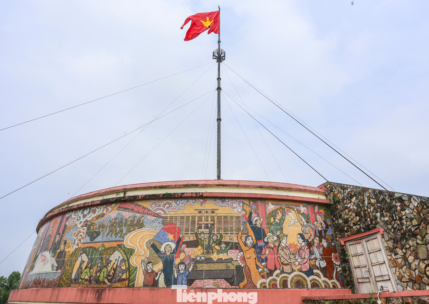 Cột cờ hiện nay có thêm phần đài, được trang trí bằng các bức tranh gốm liên hoàn.