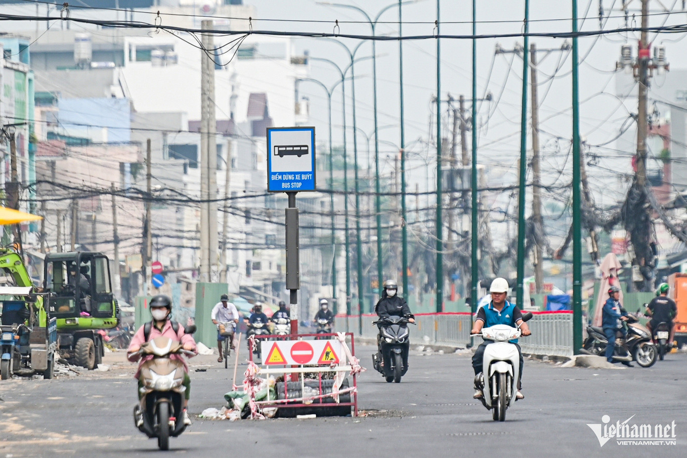Một điểm dừng - đón trả khách đi xe buýt chưa được di dời, nằm án ngữ giữa đường.