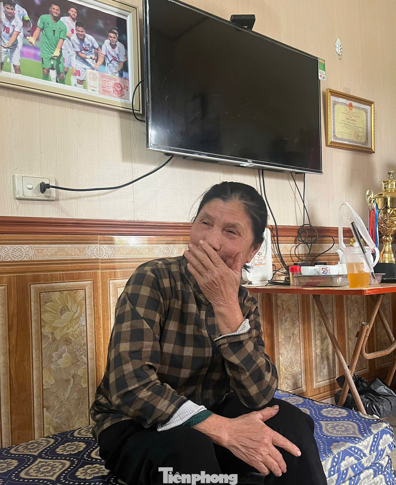 Mẹ Đình Triệu ngồi trên tấm nệm để ở gian chính, kể lại quãng thời gian khó khăn trong xúc động. (Ảnh: Thanh Hải)