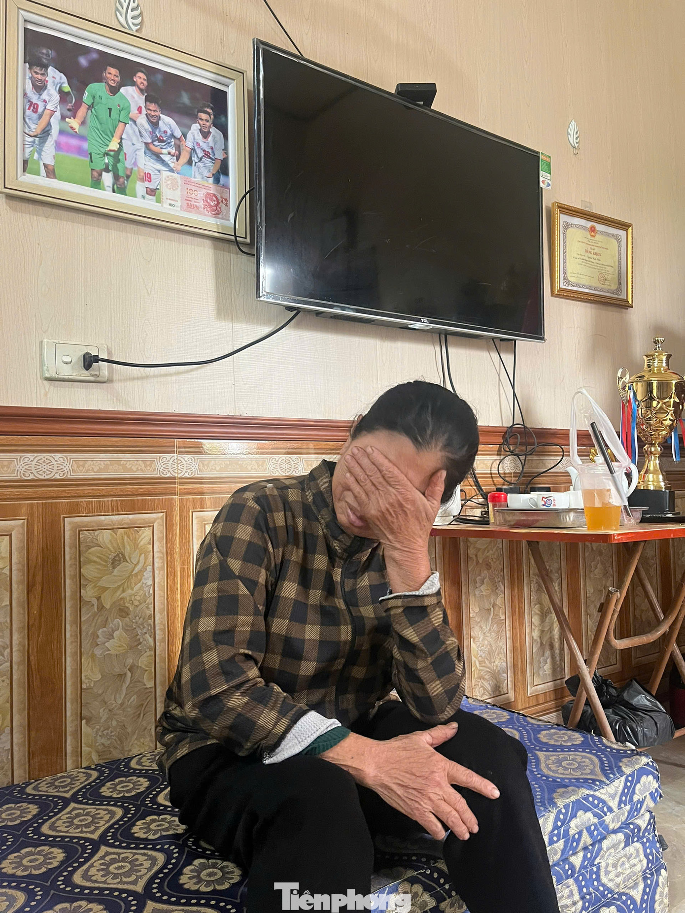 Mẹ Đình Triệu ngồi trên tấm nệm để ở gian chính, kể lại quãng thời gian khó khăn trong xúc động. (Ảnh: Thanh Hải)