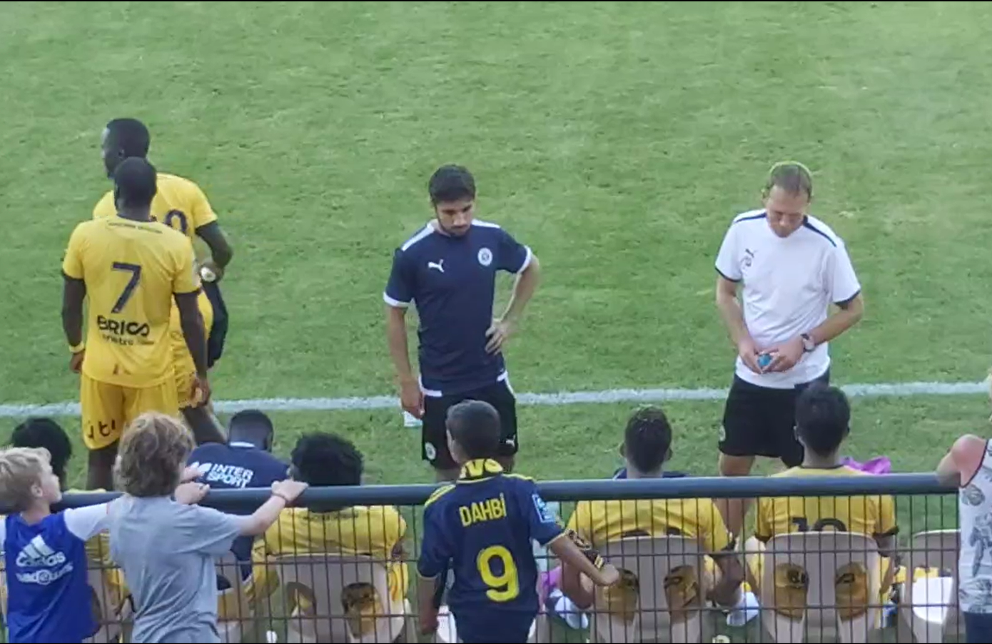 Trợ lý HLV trao đổi với Quang Hải trong giờ nghỉ (trái) và Quang Hải khoác vai đồng đội (phải). (Ảnh: video Sỹ Tuân)