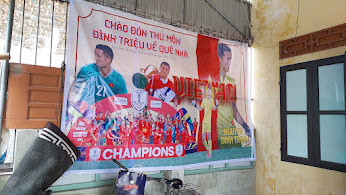 Nhà Đình Triệu, trước vốn là cái ao, nằm khiêm tốn cuối ngõ, và trong mảnh sân nhỏ là tấm backrop chào mừng anh trở về sau chiến tích vô địch cùng đội tuyển Việt Nam. (Ảnh: Thanh Hải)
