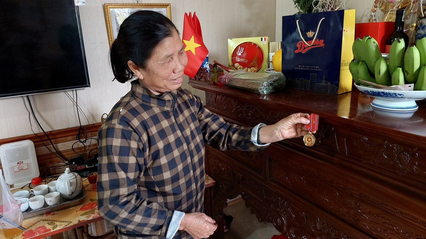 Bà Nhĩn khoe tấm Huân chương Lao động hạng ba được Chủ tịch nước trao tặng cho Đình Triệu, cùng các kỷ vật khác trong sự nghiệp của con trai. (Ảnh: Thanh Hải)