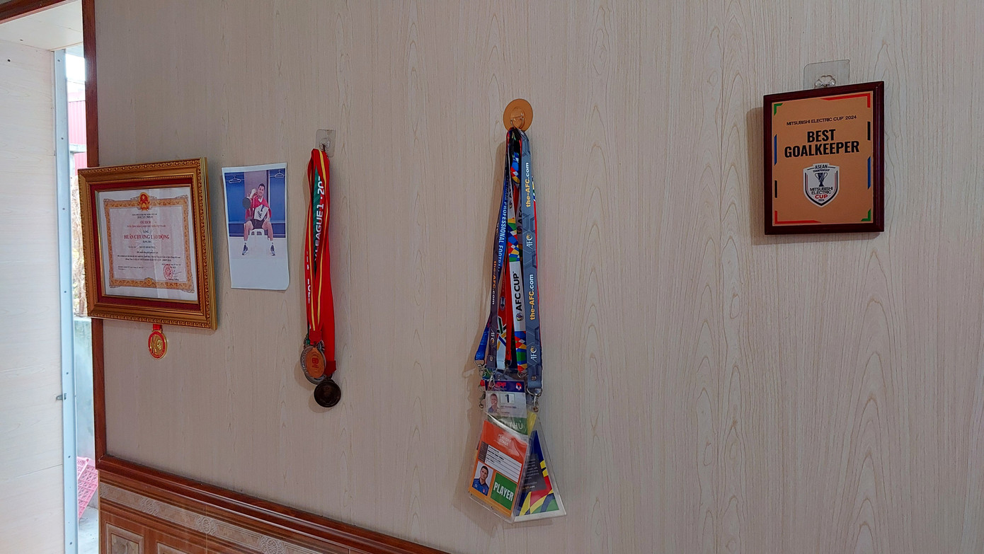 Bà Nhĩn khoe tấm Huân chương Lao động hạng ba được Chủ tịch nước trao tặng cho Đình Triệu, cùng các kỷ vật khác trong sự nghiệp của con trai. (Ảnh: Thanh Hải)