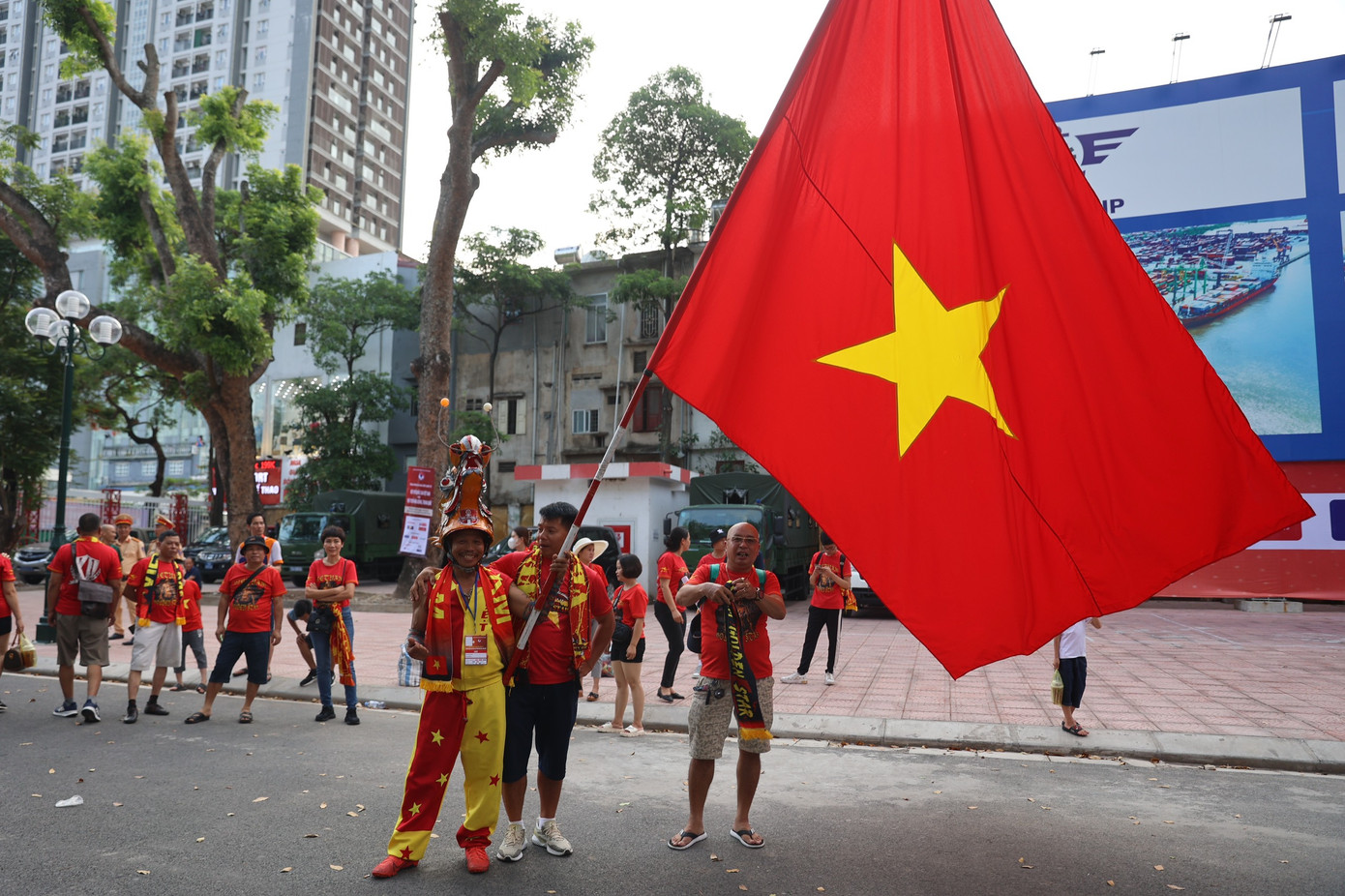 Chú Nguyễn Quang Định, hay còn gọi là &quot;Định đầu rồng&quot; hoặc &quot;Gã điên đất Cảng&quot;, trong bộ trang phục quen thuộc cùng chiếc đầu rồng. Chia sẻ với báo Tiền Phong, chú nói chiếc đầu rồng này được làm từ hồi SEA Games 25, khi chú rong ruổi trên chiếc xe máy sang tận Lào cổ vũ Việt Nam.