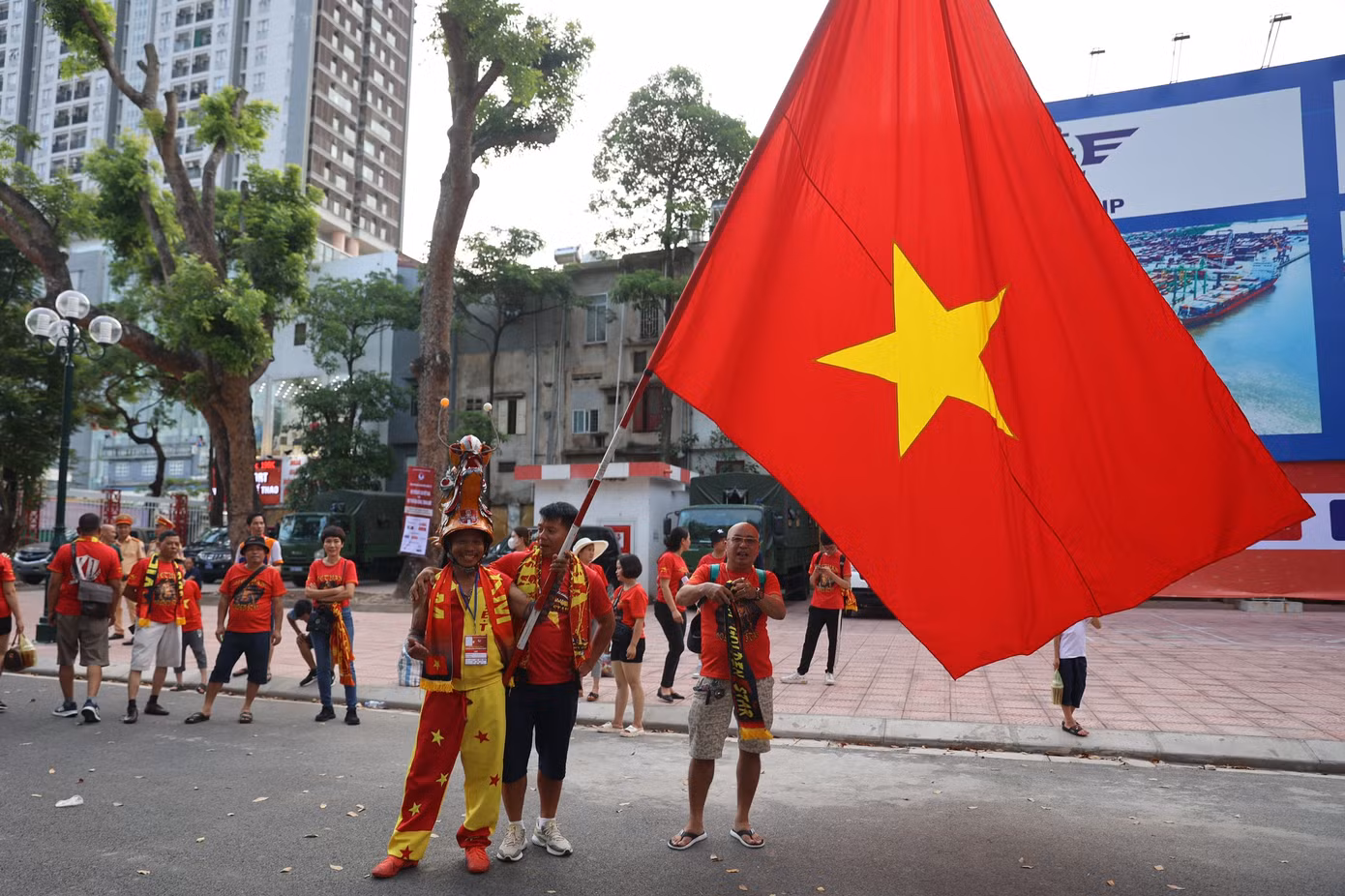Chú Nguyễn Quang Định, hay còn gọi là "Định đầu rồng" hoặc "Gã điên đất Cảng", trong bộ trang phục quen thuộc cùng chiếc đầu rồng. Chia sẻ với báo Tiền Phong, chú nói chiếc đầu rồng này được làm từ hồi SEA Games 25, khi chú rong ruổi trên chiếc xe máy sang tận Lào cổ vũ Việt Nam.