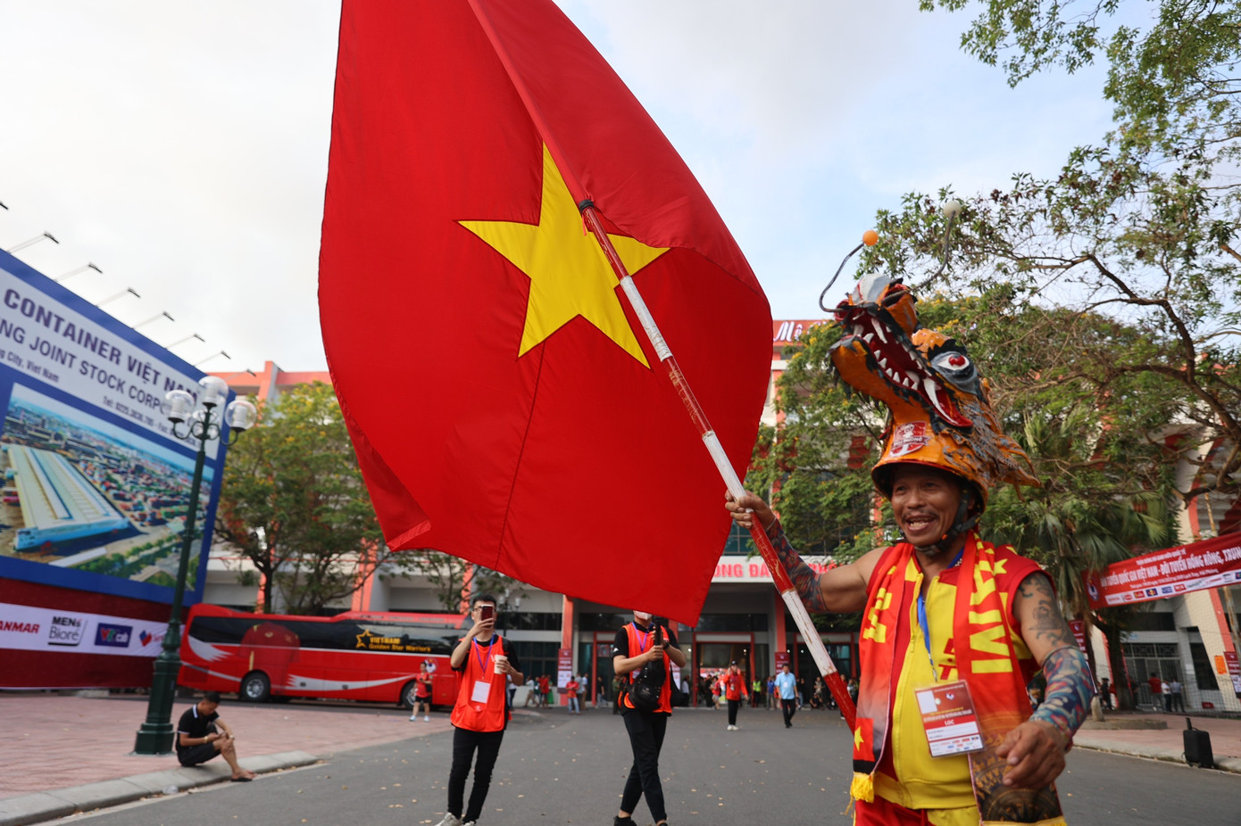 Chú Nguyễn Quang Định, hay còn gọi là &quot;Định đầu rồng&quot; hoặc &quot;Gã điên đất Cảng&quot;, trong bộ trang phục quen thuộc cùng chiếc đầu rồng. Chia sẻ với báo Tiền Phong, chú nói chiếc đầu rồng này được làm từ hồi SEA Games 25, khi chú rong ruổi trên chiếc xe máy sang tận Lào cổ vũ Việt Nam.