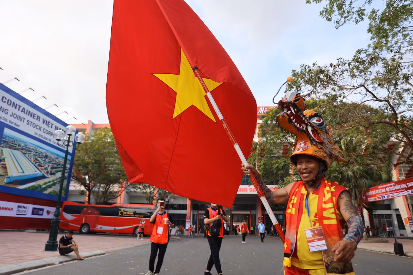 Chú Nguyễn Quang Định, hay còn gọi là "Định đầu rồng" hoặc "Gã điên đất Cảng", trong bộ trang phục quen thuộc cùng chiếc đầu rồng. Chia sẻ với báo Tiền Phong, chú nói chiếc đầu rồng này được làm từ hồi SEA Games 25, khi chú rong ruổi trên chiếc xe máy sang tận Lào cổ vũ Việt Nam.