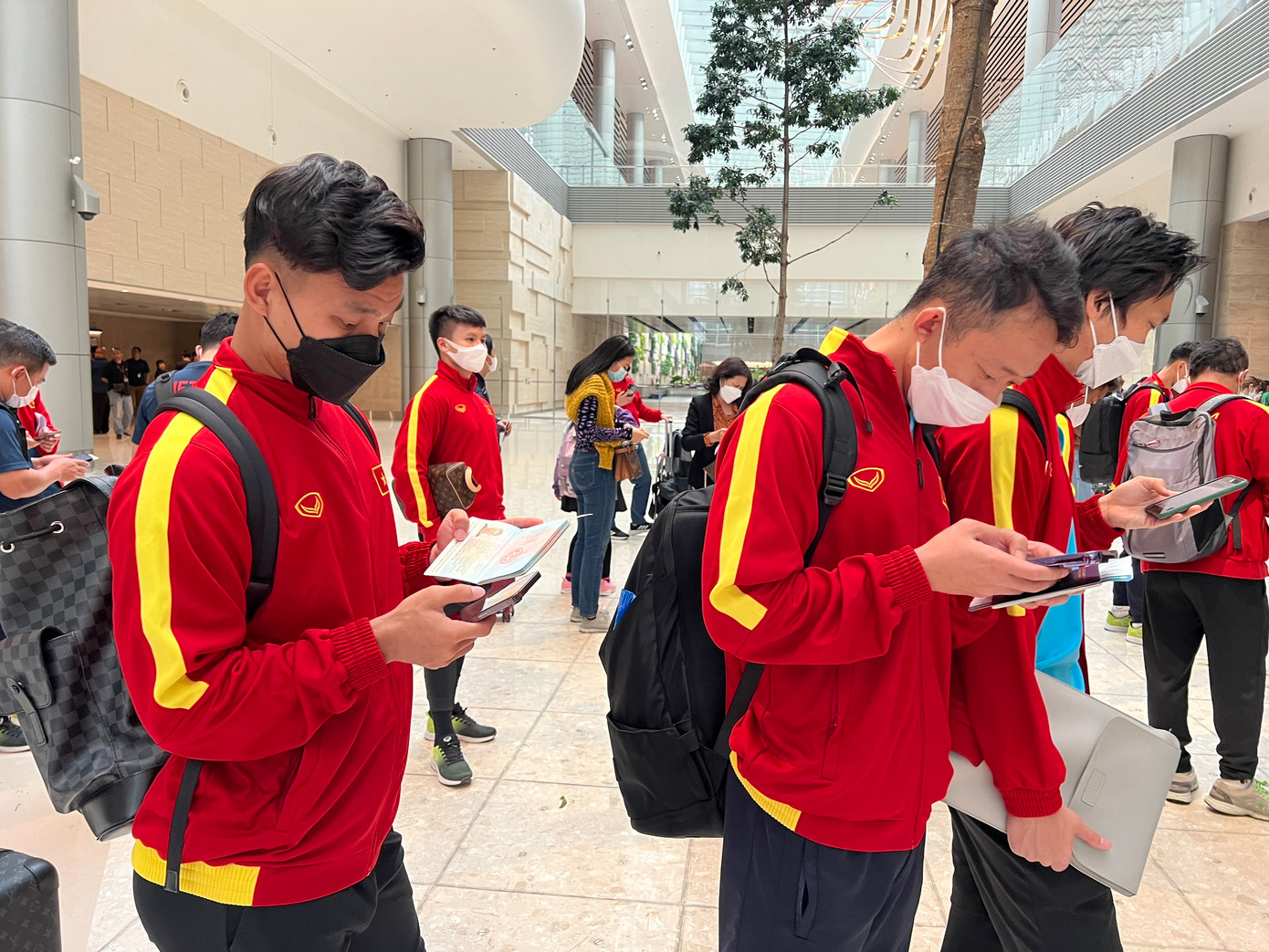 Hầu hết các cầu thủ đều tập trung vào điện thoại của mình.