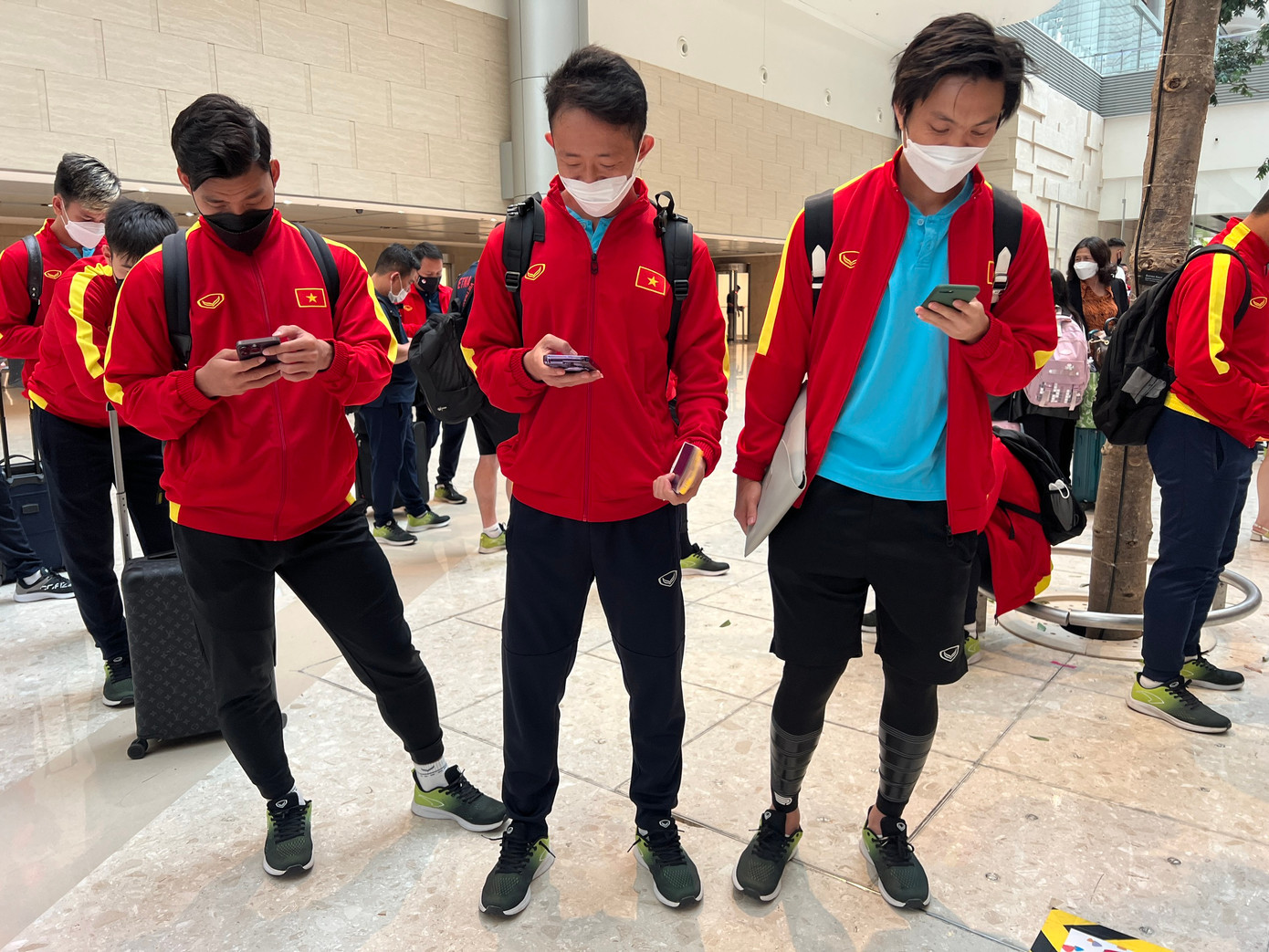 Hầu hết các cầu thủ đều tập trung vào điện thoại của mình.